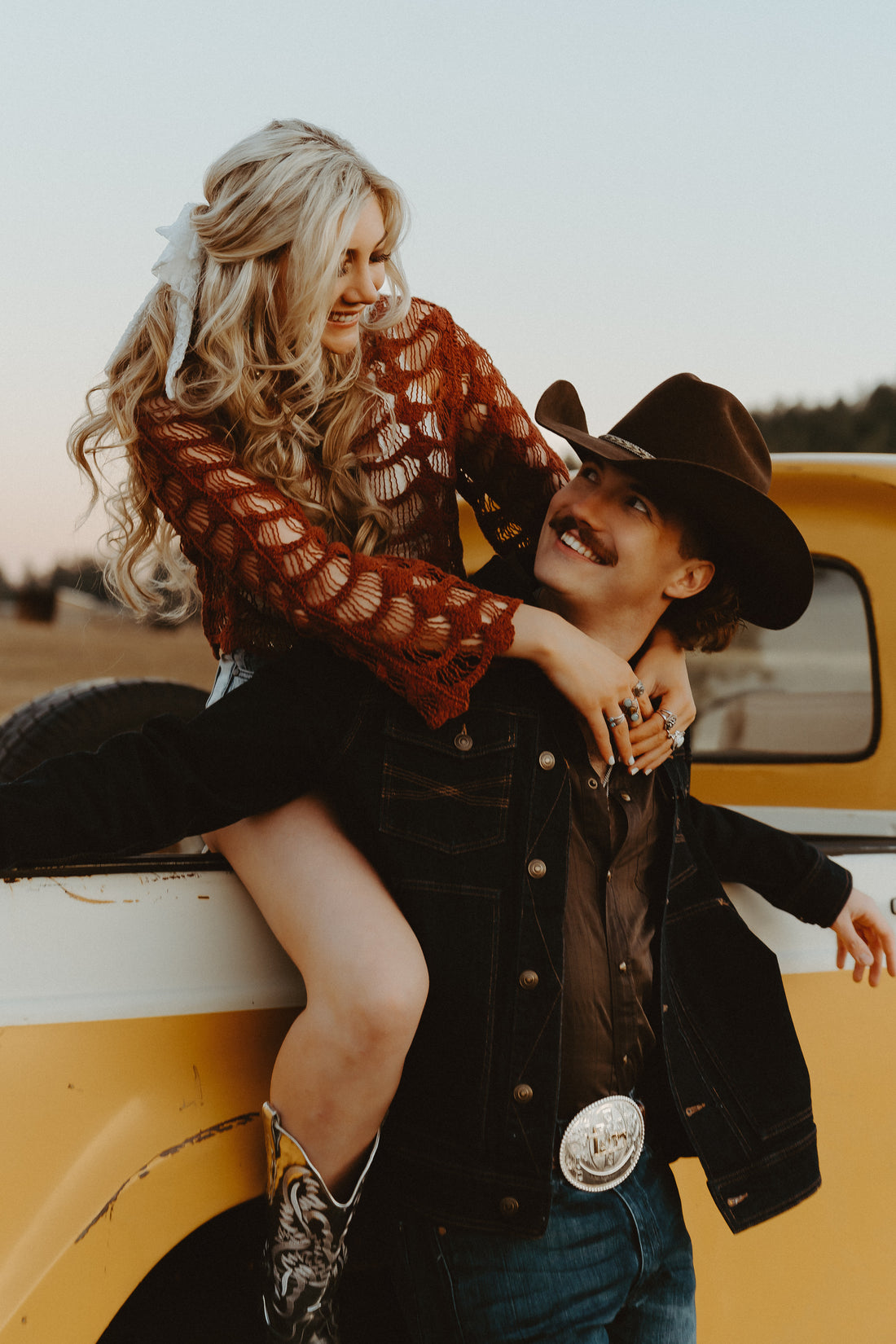 The couple behind Wyld Jace Co sitting on a vintage yellow truck